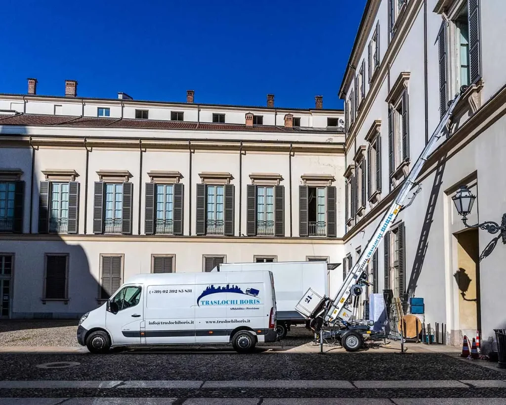Furgone e autoscala di Traslochi Boris in azione per un trasloco presso un palazzo storico.